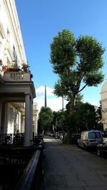 Cars on city street against clear sky