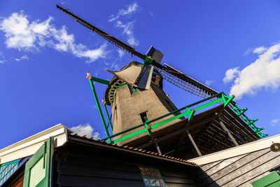 Low angle view of traditional windmill against building