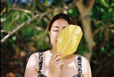 Young woman holding leaf