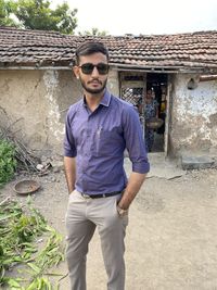 Portrait of young man wearing sunglasses standing outdoors