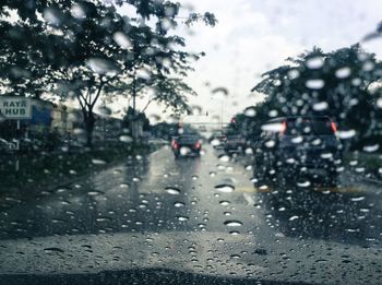 Cars on road seen through wet window