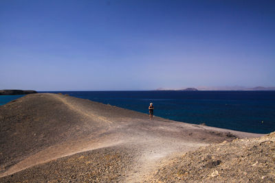 Scenic view of beach against clear blue sky