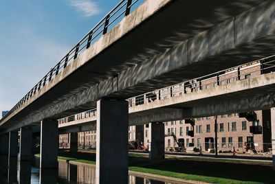 Low angle view of bridge against buildings in city