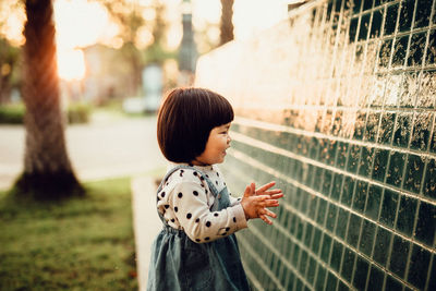 Rear view of woman standing against wall