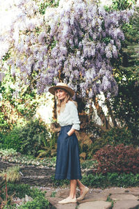 Woman in boater straw hat with wisteria vertical image
