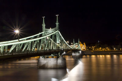 Illuminated liberty bridge over river at night