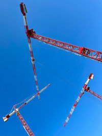 Low angle view of crane against clear blue sky