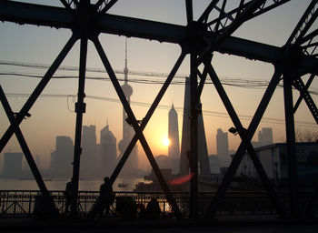 Silhouette bridge against sky during sunset