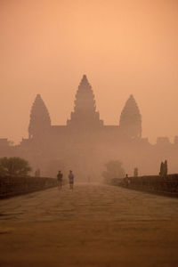 Group of people in foggy weather at sunset