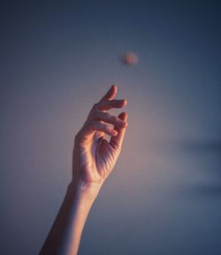 Low angle view of hand against sky during sunset