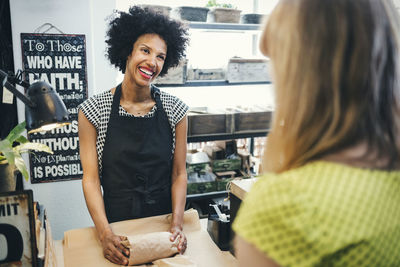 Smiling young woman standing at store