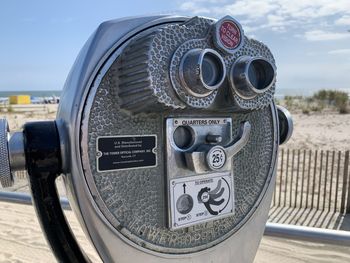 Close-up of coin-operated binoculars against sky