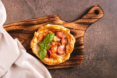 Close up of chicago pizza pot pie with sausage, tomatoes and cheese on a board top view