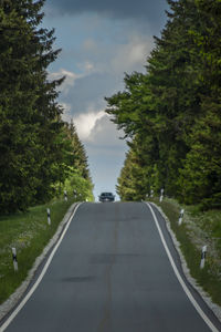 Road amidst trees against sky