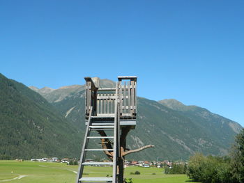 Built structure on landscape against clear blue sky