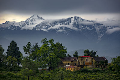 Houses on snowcapped mountains against sky