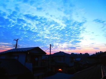 Low angle view of silhouette buildings in town against sky