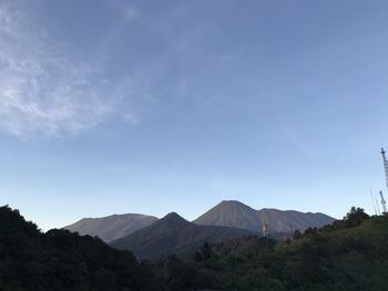 Scenic view of mountains against blue sky