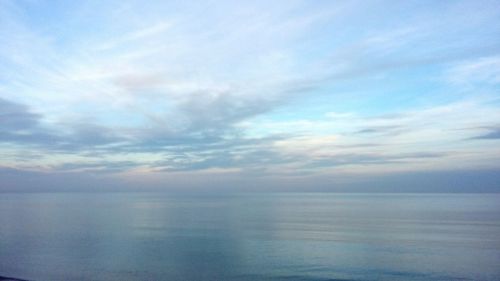 Scenic view of calm sea against cloudy sky