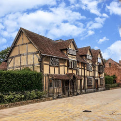 Houses by road against sky in city