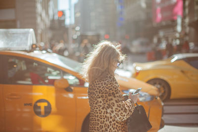 Side view of woman in cheetah print cloth walking on street