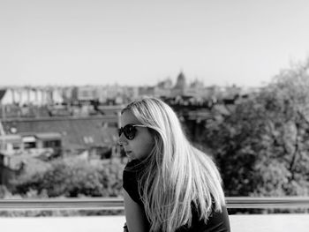 Rear view of woman sitting against sky