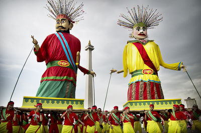 People in traditional windmill against sky