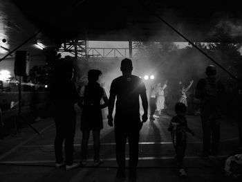 People on sidewalk in city at night