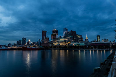 Illuminated buildings in city at waterfront