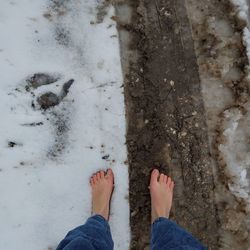 Person with one foot in clean snow and one in dirty snow