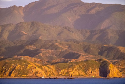 Scenic view of sea and mountains against sky