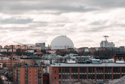 Buildings in city against cloudy sky