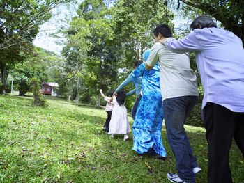 Rear view of multi-generation family playing in park