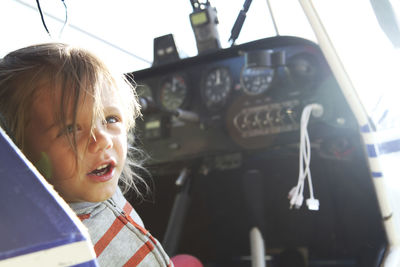 Close-up of cute girl sitting in air vehicle