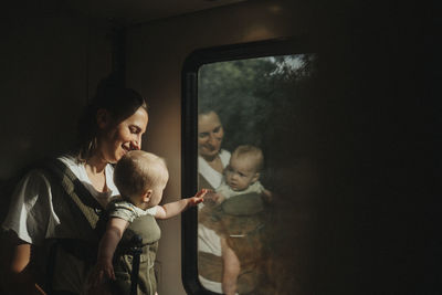 Mother with baby looking through train window