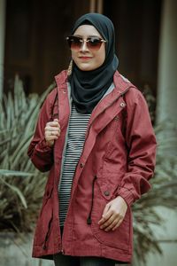 Portrait of young woman wearing sunglasses standing outdoors