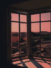 Buildings seen through window during sunset