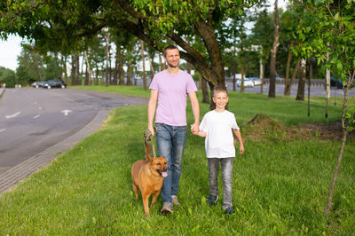 Portrait of woman with dog on grassy field