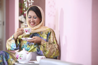 Woman drinking coffee while sitting at home