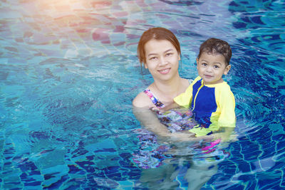 Portrait of mother with son in swimming pool