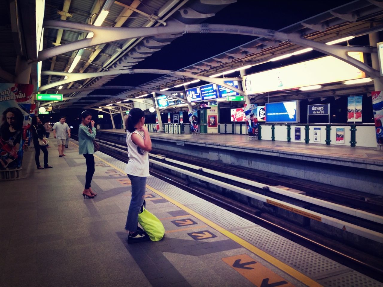 PEOPLE WALKING ON RAILROAD STATION PLATFORM