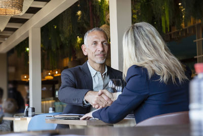 Businessman shaking hands with client in restaurant