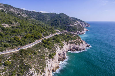 High angle view of sea by mountains against sky