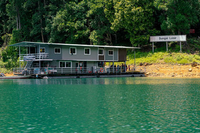 Built structure on lake against trees and plants