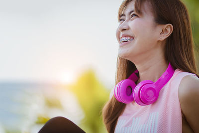 Smiling woman looking away against sky