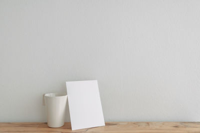 Close-up of paper and mug on table