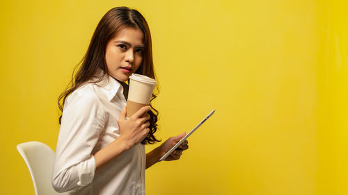 Portrait of young woman drinking coffee