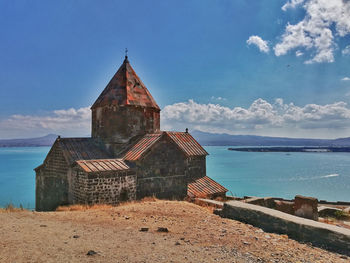 Exterior of building by sea against sky