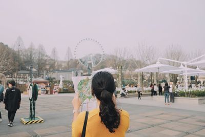 Rear view of people at amusement park in city