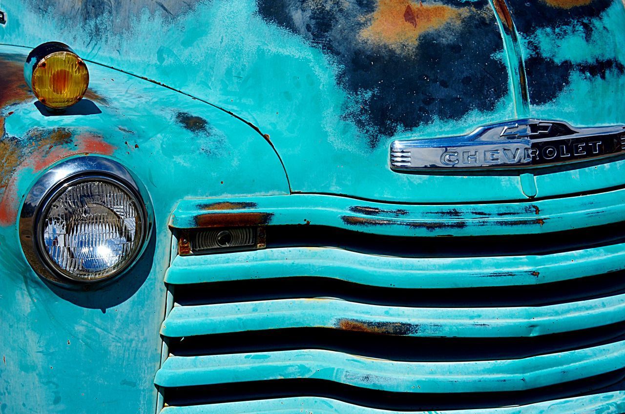 CLOSE-UP OF OLD CAR AGAINST BLUE WATER